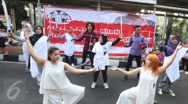 Sejumlah orang yang tergabung dalam relawan Kawan8 dan Mahasiswa IKJ yang menggelar flashmob di Jalan Jenderal Sudirman, Jakarta, Minggu (5/3). Acara tersebut diwarnai aksi teatrikal. (Liputan6.com/Helmi Afandi)