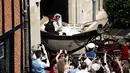 Pangeran Harry dan istrinya, Meghan Markle menaiki kereta kencana usai prosesi pernikahan di St George's Chapel, Kastil Windsor, Inggris, Sabtu (19/5). Pangeran Harry dan Meghan Markle telah resmi menikah. (Odang ANDERSEN/AFP/POOL)