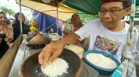 Intip ketan dimasak menggunakan cobek tanah agar memunculkan aroma rasa sedap. (Liputan6.com/Arief Pramono)