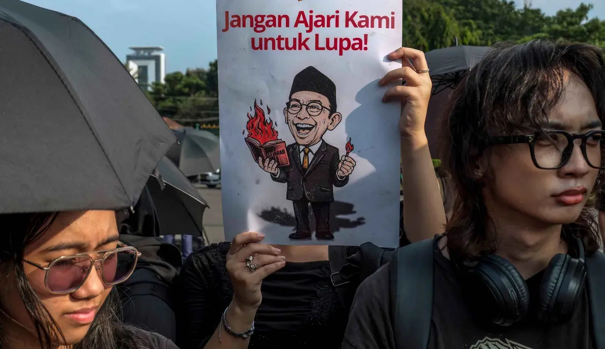 Sebagai informasi, kasus penyiraman air keras terhadap Andrie Yunus, saat ini dalam proses persidangan di Pengadilan Militer II-08 Jakarta. Insiden tersebut terjadi pada Kamis 12 Maret 2026 malam di kawasan Senen, Jakarta Pusat, dan melibatkan empat orang prajurit TNI sebagai tersangka. Tampak dalam foto, para aktivis memegang payung hitam dan poster selama Aksi Kamisan di depan Istana Kepresidenan, Jakarta, Kamis 30 April 2026. (BAY ISMOYO/AFP)