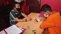Seorang tahanan di Polres Siak melakukan video call dengan keluarga untuk menjaga jarak guna menghindari virus corona. (Liputan6.com/M Syukur)