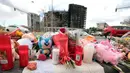Foto ini menunjukkan bunga dan lilin yang diletakkan di trotoar setelah kebakaran besar menewaskan sepuluh orang di sebuah blok perumahan bertingkat di Valencia pada 26 Februari 2024. (Mao/AFP)
