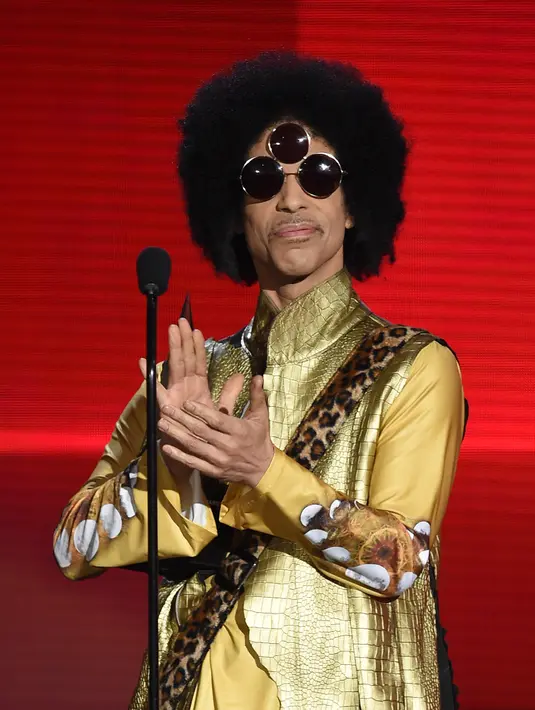 Prince tampil nyentrik dengan busana serba emasnya ditambah dengan kacamata – 3 mata – yang justru membuat penampilannya semakin aneh. (AFP/Bintang.com)