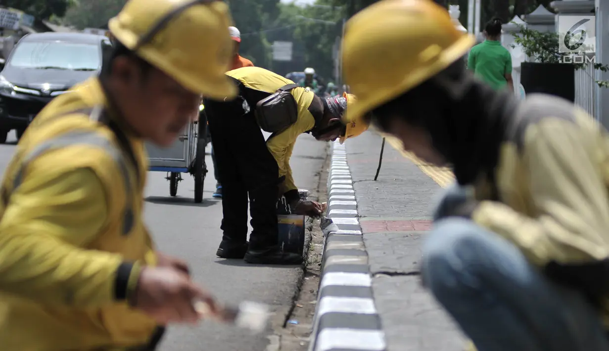 Petugas Suku Dinas Bina Marga Jakarta Timur saat menyelesaikan pengecatan trotoar di Jalan Persahabatan Raya, Jakarta, Rabu (27/3). Kegiatan pengecatan ini rutin dilakukan guna merawat sekaligus mempercantik jalur pedestrian tersebut. (merdeka.com/Iqbal S. Nugroho)