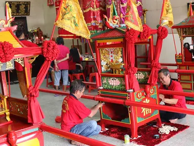 Sejumlah orang menghias tandu untuk arak-arakan dalam perayaan Cap Go Meh di Vihara Amurva Bhumi, Jatinegara, Jakarta, Sabtu (3/3). Warga keturunan tionghoa bakal mengarak patung dewa yang diletakkan di tandu itu. (Liputan6.com/Immanuel Antonius)