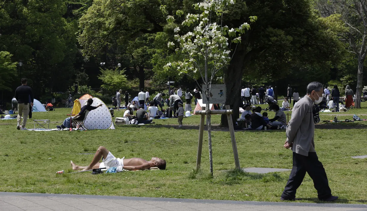 Shiba Park penuh dengan keluarga beserta anak-anak kecil yang berkemah di tenda pada hari pertama liburan 'Golden Week' di Tokyo, Jepang, 29 April 2020. Para pakar mengatakan rasa kedaruratan di masyarakat akan bahaya virus corona COVID-19 tidak ada. (AP Photo/Kiichiro Sato)