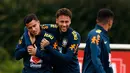 Pemain timnas Brasil Neymar menjaili rekan setimnya Philippe Coutinho saat sesi latihan di London, Inggris (29/5). Neymar dan rekan-rekannya melakukan latihan jelang pertandingan persahabatan melawan Kroasia. (AP / Kirsty Wigglesworth)