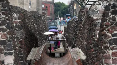 Pengunjung berjalan di Templo Mayor di kota Meksiko, (12/8). Templo Mayor merupakan bagian dari pusat sejarah kota Meksiko, yang dimasukan ke Daftar Warisan Dunia UNESCO pada tahun 1987. (AFP Photo/Rodrigo Arangua)