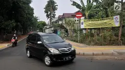 Mobil melintas di dekat spanduk larangan berjualan hewan kurban di kawasan Pulomas, Jakarta, Rabu (4/7). Larangan tersebut karena berbarengan dengan  Asian Games 2018 di sekitar arena pacuan kuda atau Equestrian Pulomas. (Merdeka.com/Iqbal S. Nugroho)