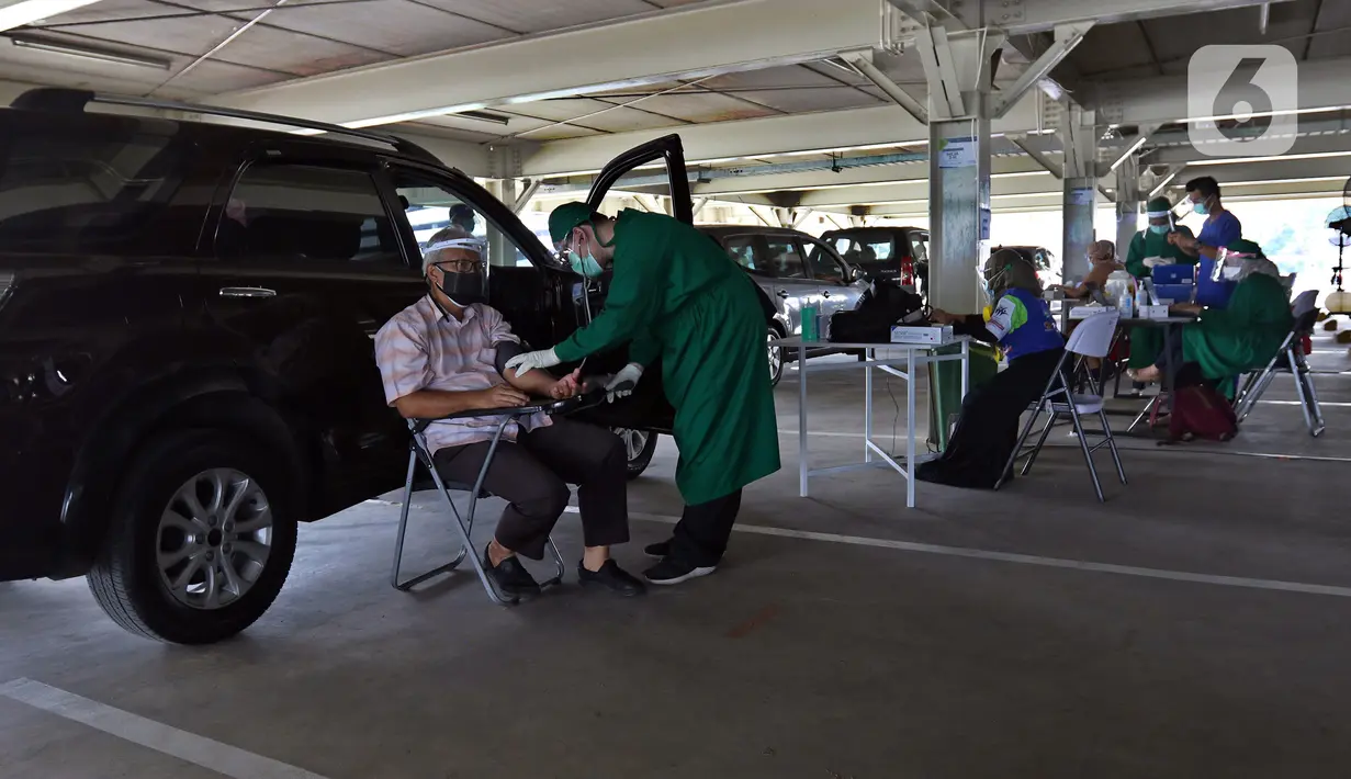 Petugas medis memeriksa kondisi lansia saat vaksinasi COV-19 secara drive thru di RSUI, Depok, Jawa Barat, Kamis (25/3/2021). XL Axiata bekerja sama dengan RSUI yang didukung Kemenkes dan Pemkot Depok menggelar program Sentra Vaksinasi Indonesia Bangkit untuk lansia. (Liputan6.com/Herman Zakharia)
