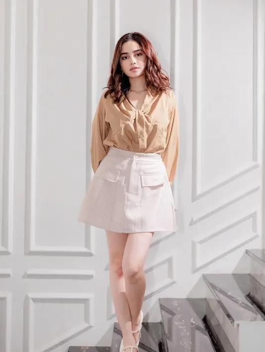 Gaya chic Syifa Hadju pakai blouse cokelat lengan panjang dipadunya dengan mini skirt putih gading yang serasi. [Foto: Instagram/syifahadju]