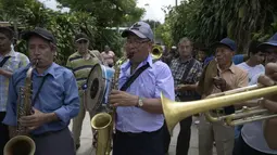 Pria memainkan musik selama perayaan Santa Cruz di Santa Maria Ostuma, 65 km timur San Salvador (31/5/2022). Ratusan orang Salvador membawa buah dengan yodes kayu berjalan melalui desa Santa Maria Ostuma di El Salvador tengah untuk berterima kasih kepada Salib Suci atas panen yang melimpah. (AFP/MARVIN RECINOS)