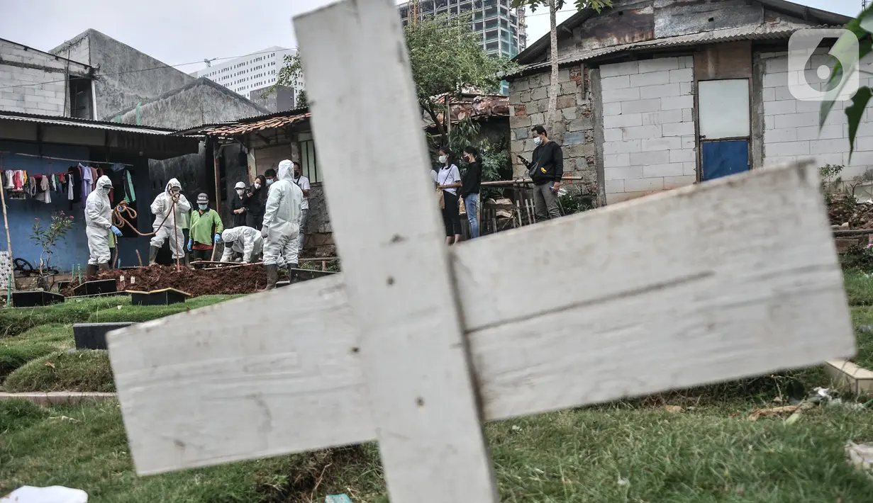 Petugas mengenakan baju hazmat saat memakamkan jenazah pasien Covid-19 isolasi mandiri di TPU Pondok Kelapa, Jakarta, Selasa (13/7/2021). Tim Koalisi Warga LaporCovid-19 mencatat sebanyak 451 pasien Covid-19 meninggal saat menjalani isolasi mandiri. (merdeka.com/Iqbal S Nugroho)
