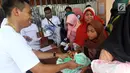 Anak-anak mengambil bantuan berupa perlengkapan sekolah saat Natal bersama dan bantuan CSR Sinergi BUMN di Kota Waingapu, Sumba Timur, Sabtu (15/12). BUMN kembali bersinergi meningkatkan kehidupan sosial. (Liputan6.com/JohanTallo)