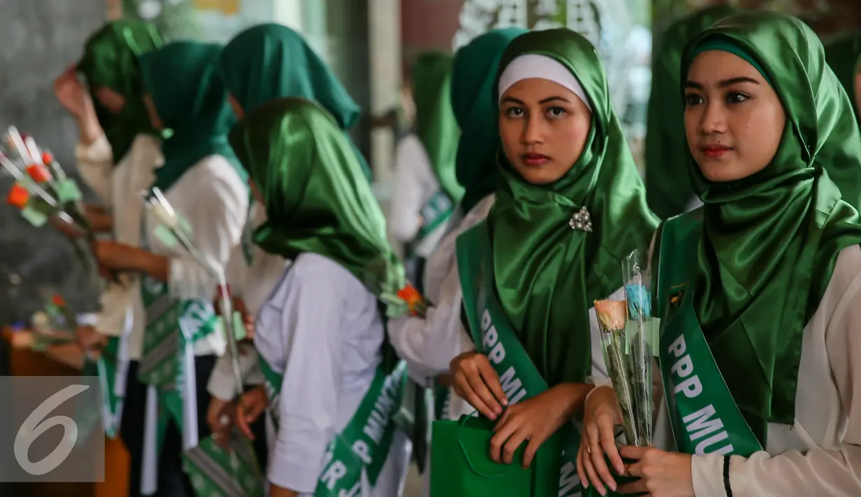 Sejumlah Simpatisan perempuan muda PPP membagikan bunga kepada pegawai dan pengunjung di Kantor Kementerian Hukum dan Ham, Jakarta, Senin (11/1). Aksi damai tersebut mendesak penyelesaian konflik pengurusan partai PPP. (Liputan6.com/Faizal Fanani)