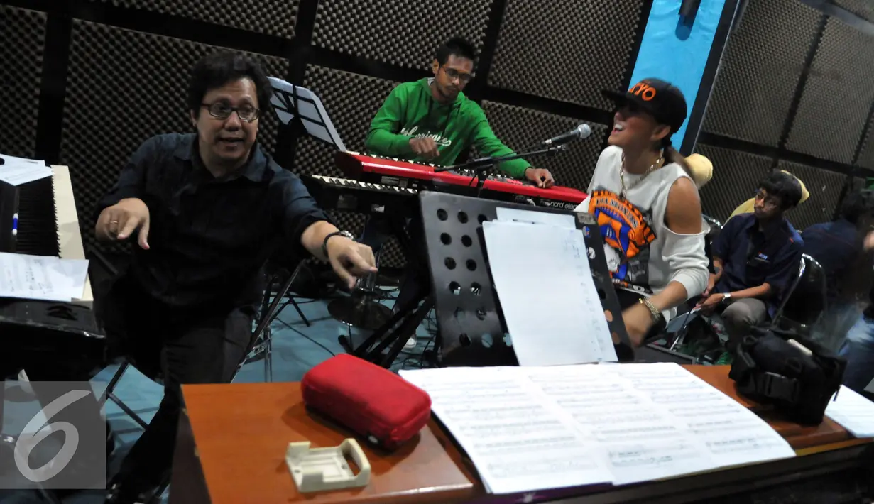Komposer Erwin Gutawa (kiri) saat melakukan latihan bersama Agnez Mo latihan di studio Erwin Gutawa, Jakarta.  Jumat (21/08/2015). Ada tiga lagu yang bakal dinyanyikan Agnez Mo di malam puncak HUT SCTV nanti. (Liputan6.com/Panji Diksana)