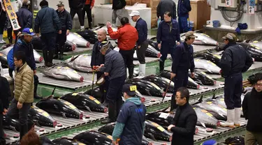 Orang-orang menghadiri tradisi lelang Tahun Baru di Pasar ikan Toyosu, Tokyo, Minggu (5/1/2020). Lelang ikan ini adalah kegiatan rutin usai Tahun Baru yang biasanya diadakan menjelang fajar di pasar ikan Toyosu. (Kazuhiro NOGI / AFP)