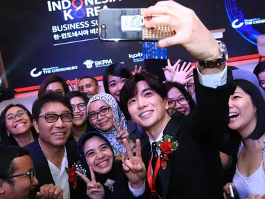 Salah satu personel Super Junior, Leeteuk berselfie bersama peserta saat menghadiri acara Indonesia-Korea Business Summit 2017 di Hotel Shangri-La, Jakarta, Selasa (14/3). (Liputan6.com/Herman Zakharia)