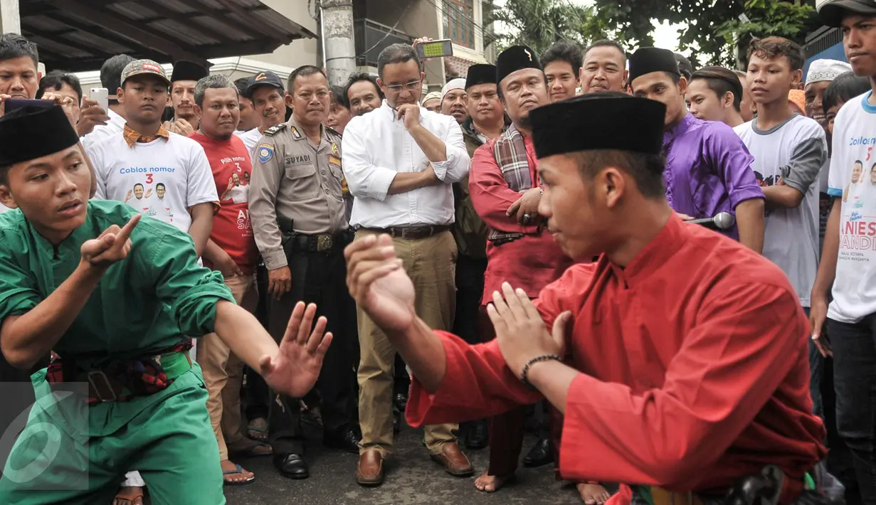 Cagub DKI Jakarta, Anies Baswedan menyaksikan seni silat tradional Betawi 'palang Pintu' saat mengunjungi kawasan Menteng Dalam, Jakarta, Kamis (2/2). (Liputan6.com/Yoppy Renato)