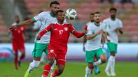 Pemain Oman Arshad al-Alawi (tengah) dibayangi pemain Arab Saudi Ali al-Bulaihi (kiri) pada pertandingan sepak bola Kualifikasi Piala Dunia 2022 di Stadion King Abdullah Sport City, Jeddah, Arab Saudi, 27 Januari 2022. Arab Saudi menang 1-0. (AFP)