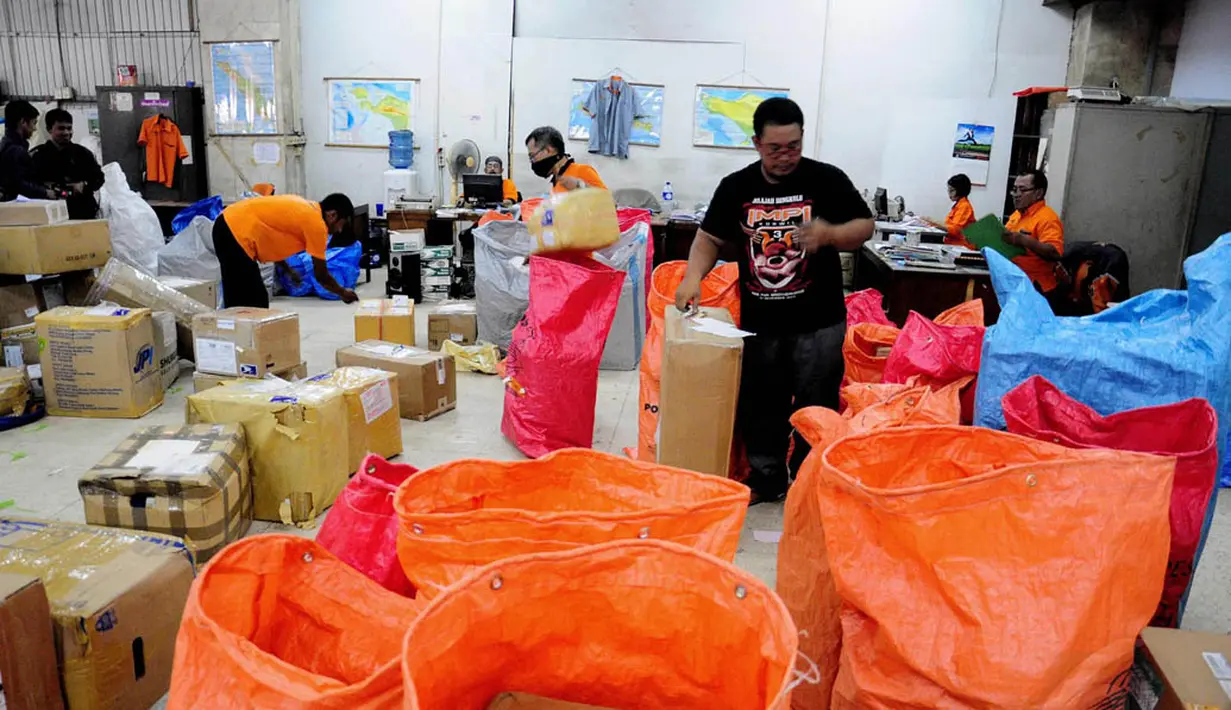 Petugas di Kantor Pos Pasar Baru memilah paket pos sesuai daerah tujuan yang akan dikirim, Jakarta, Selasa (1/7/14). (Liputan6.com/Faizal Fanani)