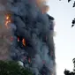 Asap dan api menyelimuti sebuah apartemen bertingkat 27 lantai yang terbakar di London (14/6). Gedung apartemen tersebut terbakar mulai dari lantai dua hingga puncak bangunan. (AP Photo/Matt Dunham)