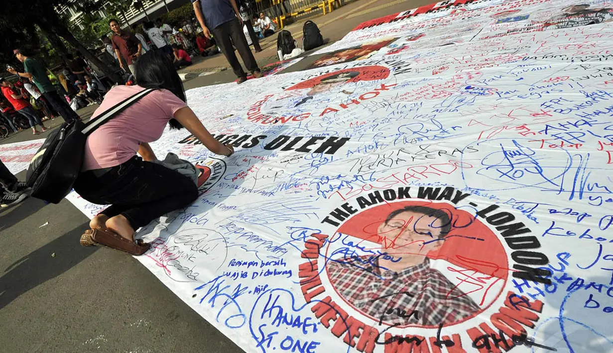 Sejumlah relawan Ahok melakukan aksi tanda tangan sebagai bentuk dukungan menjadi Gubernur DKI di Bundaran HI, Jakarta, Minggu (9/11/2014). (Liputan6.com/Miftahul Hayat)