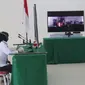 Salah seorang pedagang menghadap layar menjalani sidang yustisi secara virtual karena melanggar aturan PPKM Darurat. Sidang digelar di Gedung Mini Perkantoran Terpadu Pemkot Malang pada Senin, 19 Juli 2021 (Kominfo Kota Malang)alai Ko