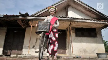 Seorang gadis menggunakan sepeda saat hendak menuju titik kumpul untuk mengikuti upacara adat Ngarot di Desa Lelea, Indramayu, Jawa Barat, Rabu (19/12). Ngarot merupakan tradisi yang diikuti gadis 'perawan'. (Merdeka.com/Iqbal Nugroho)
