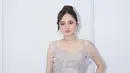Syifa Hadju mengenakan mini dress abu-abu silver. Dress sleeveless tersebut semakin indah dengan aksen kupu-kupu yang menjuntai di bagian rok dan aksen kupu-kupu berkilau di bagian dada.  [@krinouofficial]