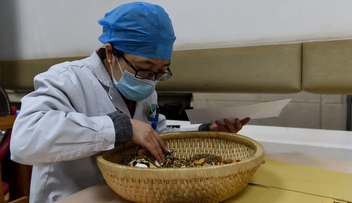 Apoteker meracik obat tradisional China di Rumah Sakit Afiliasi Pertama Universitas Kedokteran China di Hefei, 24 Februari 2020. RS itu bertanggung jawab meracik, merebus dan mengirim obat tradisional China ke tujuh rumah sakit yang ditunjuk untuk merawat pasien COVID-19 di Hefei. (Xinhua/Zhou Mu)