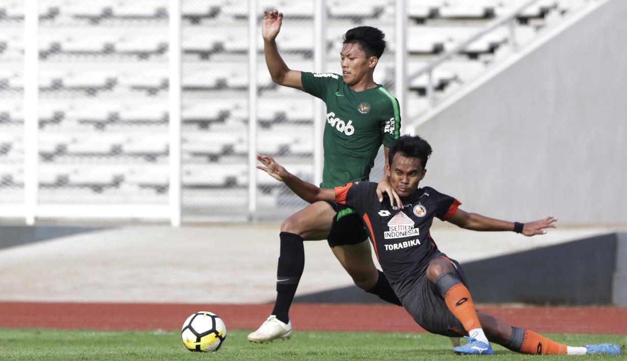 Gelandang Timnas Indonesia U-23, Feby Eka Putra, berusaha merebut bola saat melawan Semen Padang pada laga ujicoba di Stadion Madya, Jakarta, Selasa (12/3). Keduanya bermain imbang 2-2. (Bola.com/Vitalis Yogi Trisna)