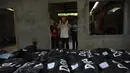 Seorang imam berdoa di depan jenazah korban pengepungan Marawi sebelum dimakamkan di sebuah pemakaman di Iligan City, di pulau selatan Mindanao (24/7). Pemerintah Filipina memperpanjang darurat militer di Marawi hingga akhir tahun. (AFP Photo/Ted Aljibe)