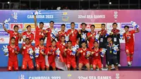 Timnas Indonesia U-22 berselebrasi di podium setelah memenangkan pertandingan final sepak bola putra melawan Thailand 5-2 pada SEA Games 2023 di Phnom Penh, Kamboja, Selasa, 16 Mei 2023. Sukses ini mengakhiri penantian 32 tahun meraih medali emas sepak bola SEA Games. (foto: Nhac NGUYEN / AFP)