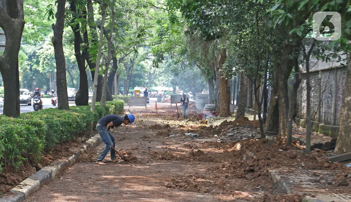 Pekerja sedang menyelesaikan pengerjaan sumur resapan di Jalan Mataram Raya, Kebayoran Baru, Jakarta, Selasa (12/10/2021). Sumur resapan atau drainase vertikal tersebut diharapkan dapat mengurangi titik-titik rawan banjir di Ibu Kota. (Liputan6.com/Herman Zakharia)