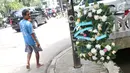 Pejalan kaki mengamati tiang lampu di lokasi kecelakaan Setya Novanto di Jalan Permata Berlian, Jakarta, Sabtu (18/11). Pada karangan itu tertulis pesan "Walau Sudah Ditabrak Semoga Hukum Kita Setegak Tiang Ini #GetWellSoon." (Liputan6.com/Angga Yuniar)