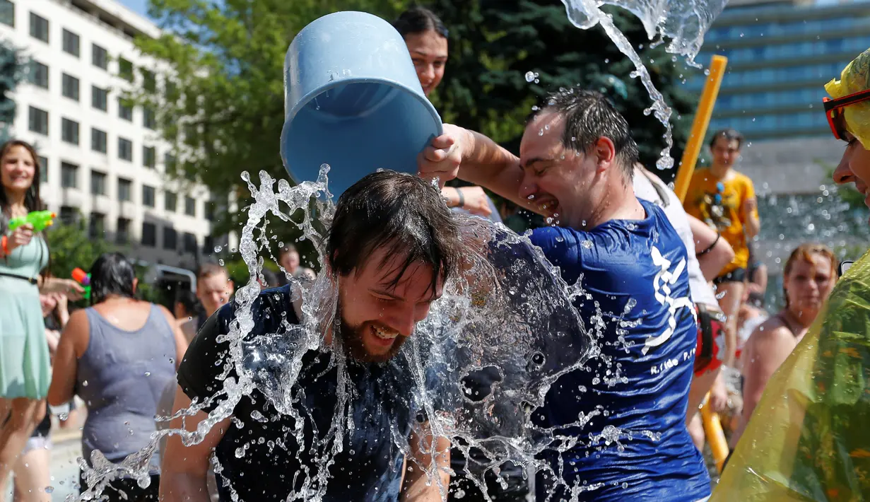 Seorang lelaki disiram air saat acara perang air di Budapest, Hungaria (25/6). (REUTERS/Laszlo Balogh)