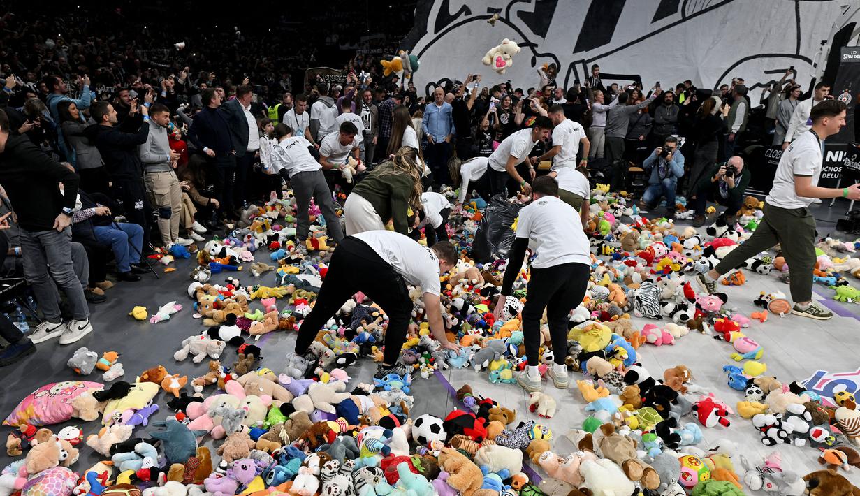 Sejumlah petugas mengumpulkan sejumlah boneka dilemparkan oleh para penonton sebelum laga lanjutan Euroleague Basketball 2024/2025 antara Partizan Belgrade melawan Maccabi Tel Aviv di Belgrade, Serbia, Jumat (03/01/2025) waktu setempat. (AFP/Oliver Bunic)