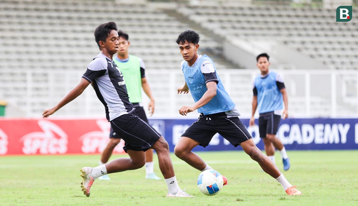 Muhammad Ragil mencoba melewati Aditya Warman pada sesi latihan bersama Timnas Indonesia U-20 di Stadion Madya, Gelora Bung Karno, Jakarta, Rabu (5/2/2025). (Bola.com/Abdul Aziz)