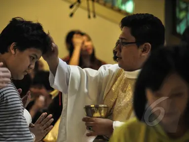 Anak berkebutuhan khusus atau penyandang difabel melakukan misa Paskah didampingi  keluarga di Gereja Santo Ignatius, Jakarta, Minggu (5/4). Misa hari ini diperuntukan bagi anak difabel agar menjalani ibadah dengan kushuk. (Liputan6.com/Faizal Fanani)