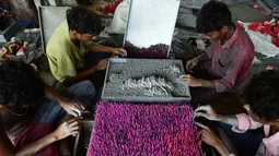Pekerja membuat petasan di bengkel jelang festival Diwali di pinggiran Ahmedabad, India (21/9/2022). Festival ini melambangkan kemenangan baik atas keburukan, dan lampu atau pelita dinyalakan sebagai tanda perayaan serta harapan umat manusia. (AFP/Sam Panthaky)