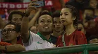 Jennifer Bachdim, istri dari pemain timnas Indoonesia, Irfan Bachdim, diajak selfie penonton saat menyaksikan laga Indonesia melawan Malaysia di Stadion Manahan, Solo, Jawa Tengah, Selasa (6/9/2016). (Bola.com/Vitalis Yogi Trisna)