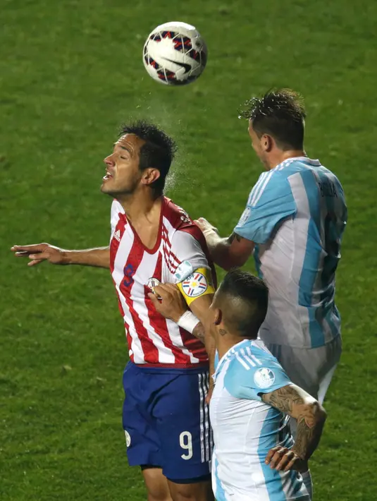 Penyerang Paraguay, Roque Santa Cruz berebut bola udara dengan bek Argentina, Marcos Rojo pada semifinal Copa Amerika 2015 di Concepcion, Chili, (1/7/2015). Argentina melangkah ke final usai mengalahkan Paraguay 6-1. (Reuters/Jorge Adorno)