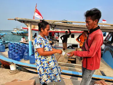 Warga kepulauan melakukan pembayaran jasa tranportasi kapal tradisional pengangkut sembako di Pulau Panjang, Banten, Sabtu (12/8/2023). Lembaga Penjamin Simpanan (LPS) terus melakukan sosialisasi sebagai upaya meningkatkan kepercayaan masyarakat terhadap industri perbankan. (Liputan6.com/Angga Yuniar)