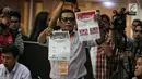 Petugas menunjukkan surat suara bagi penyandang disabilitas saat menggelar simulasi Pemilu di Jakarta, Kamis (14/2). KPU akan menempatkan petugas di tiap TPS untuk membantu pelayanan para pemilih berkebutuhan khusus. (Liputan6.com/Faizal Fanani)