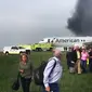 Sejumlah penumpang dievakuasi  saat pesawat American Airlines yang terbakar di Bandara O'Hare Chicago, Illinois, AS (28/10). (Jose Castillo via AP)