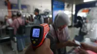 Ilustrasi pemeriksaan suhu badan kepada warga dengan menggunakan thermal gun.(Liputan6.com/Fajar Abrori)