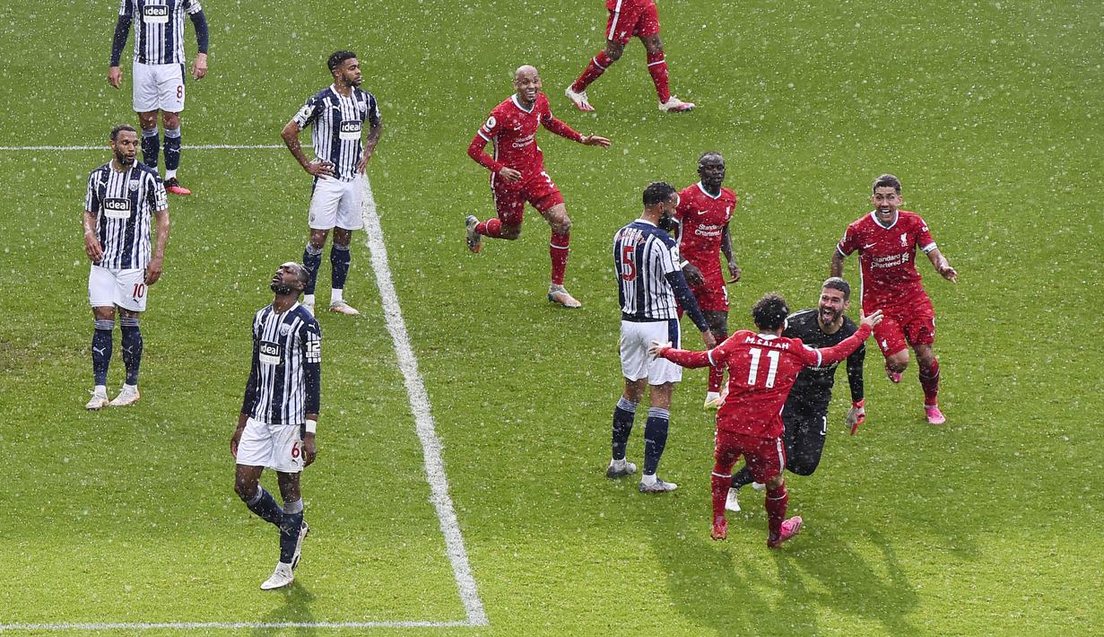 Kiper Liverpool, Alisson Becker, melakukan selebrasi usai mencetak gol ke gawang West Bromwich Albion pada laga Liga Inggris di Stadion the Hawthorns, Minggu (16/5/2021). Liverpool menang dengan skor 2-1. (Laurence Griffiths/Pool via AP)