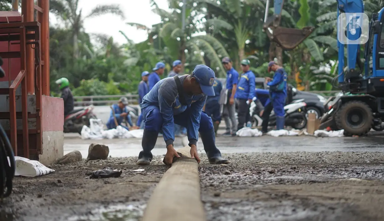 Petugas Sudin Sumber Daya Air Jakarta Timur membersihkan saluran gorong-gorong yang tertutup lumpur dan sampah di kawasan Pasar Rebo, Kamis (19/3/2020). Pembersihan untuk memperlancar sistem drainase yang tersumbat dan kerap menimbulkan genangan air di kawasan itu. (Liputan6.com/Immanuel Antonius)