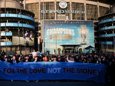 Para pendukung Manchester City melakukan protes akibat mahalnya harga tiket dengan membentangkan banner bertuliskan "MFC untuk cinta bukan uang"  sebelum laga lanjutan Liga Inggris 2024/2025 melawan Leicester di Etihad Stadium, Manchester, Inggris, Rabu (02/04/2025) waktu setempat. (AFP/Oli Scarff)
